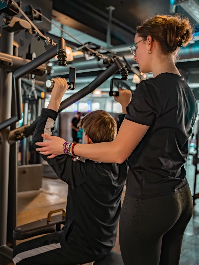 Limitless Trainer betreut einen Azubi an einem Trainingsgerät im Studio